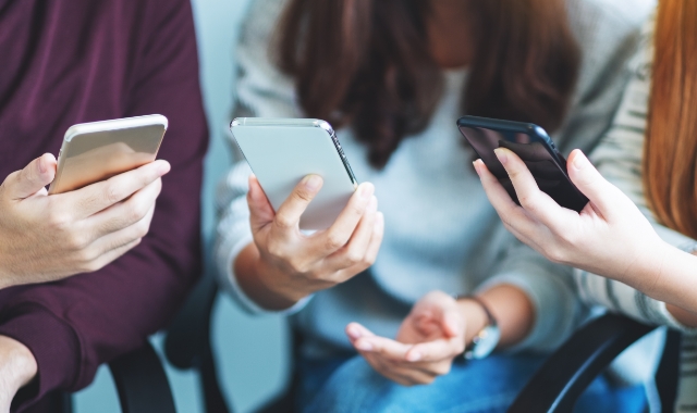 People holding phones out and looking at the screens.